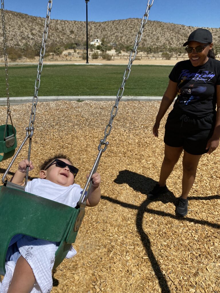 mom pushing son on swing
