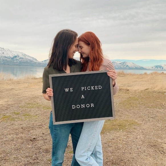 lesbian couple with sign saying "we picked a donor"