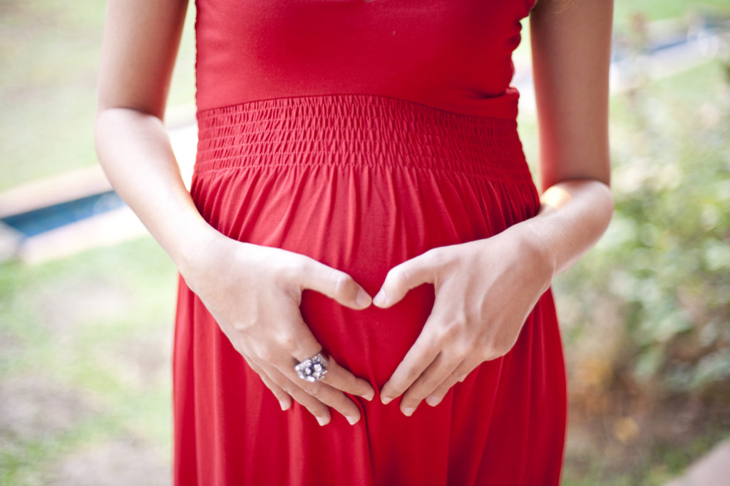 woman in a red dress with a valentines heart on her stomach