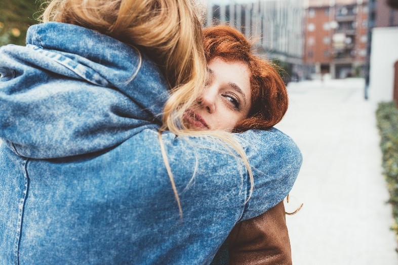 two women hugging each other 