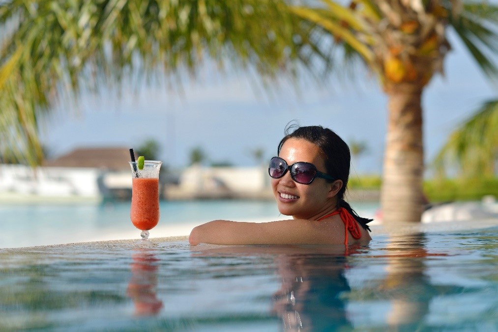 woman in the pool drinking a mocktail